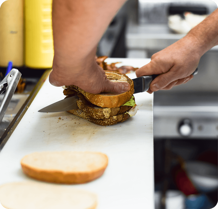 restaurant-kitchen-employee-is-cutting-a-sandwich