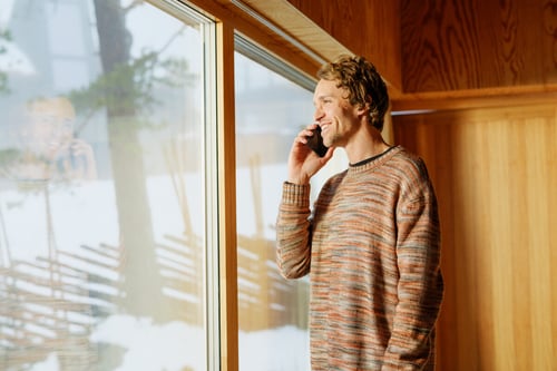 Telenor - man on phone looking out across a snowy alpine region